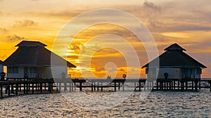 Sunset on tropical island, water villas resort