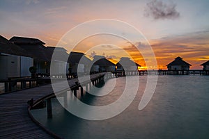 Sunset on tropical island, water villas resort