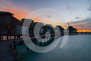 Sunset on tropical island, water villas resort