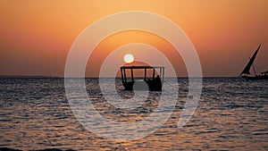 Sunset On Tropical Ocean With Big Red Sun And Silhouette Of Fishing Boats