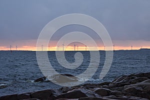Sunset, turbines and rocky shore