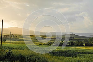 Sunset in tuscany, villa with cypress avenue in the distance