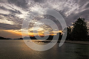 Sunset twilight sky and clolud reflect on sea beach with silhouette tree background at koh mak travel island landscape in Thailand