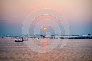 Sunset twilight sky over small barge silhouette with many stick of bamboo pole a long fishery coast ,sunset fade away in Chonburi,