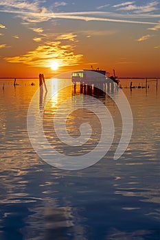 Sunset on the Venetian lagoon with the fishermen's houses, Pellestrina island, Venetian lagoon, Italy