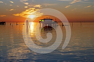 Sunset on the Venetian lagoon with the fishermen's houses, Pellestrina island, Venetian lagoon, Italy