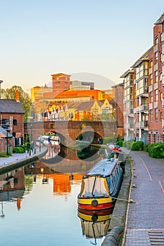 Sunset view of brick buildings alongside a water channel in the central Birmingham, England