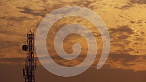 Sunset view through the cloudy sky with a communication tower