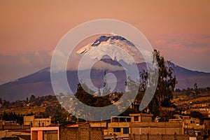 The sunset view of Cotopaxi volcano from Latacunga town, Ecuador photo