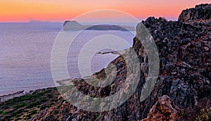 Sunset view of Gramvousa islet behind the rocky hills of Balos beach area, Crete, Greece.