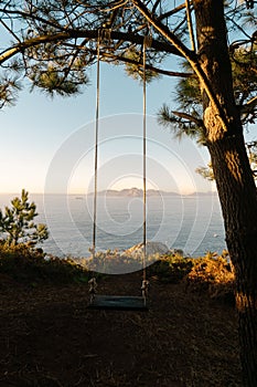 sunset view from monteferro with a rope swing hanging on a tree. Nigran - Galicia - Spain.