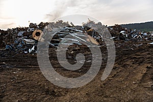 Sunset view of the mountains of scrap metal in a junkyard