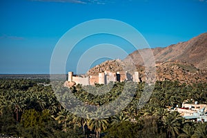 Sunset view of the Nakhal Fort surrounded by a palm grove, Oman