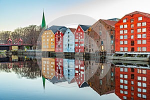 Sunset view of Nidaros cathedral and colorful timber houses surrounding river Nidelva in the Brygge district of Trondheim, Norway