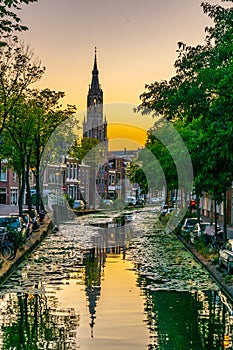 Sunset view of Niuewe Kerk church behind a channel in Delft, Netherlands