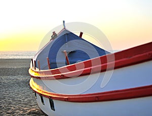 Sunset view of old wooden fisher boat at Nazare