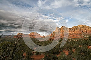 Sunset view of red rock buttes and formations within coconino national forest in Sedona Arizona USA against white cloud background