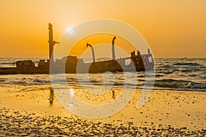 Sunset view of a rusty shipwreck in HaBonim Beach