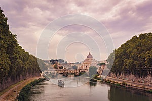 Sunset view of Saint Peter`s Basilica and Sant`Angelo`s Bridge and Tiber river