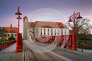 Sunset view of Sand Bridge (Most Piaskowy) with Ossolineum university, red iron bridge in Wroclaw, Poland