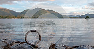 Sunset view of stone boat dock tie up ring of ancient castle ruins McCarthy Mor on Lake Leane on the Ring of Kerry Ireland