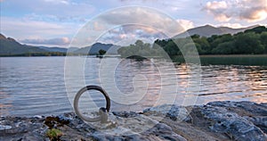 Sunset view of stone boat dock tie up ring of ancient castle ruins McCarthy Mor on Lake Leane on the Ring of Kerry Ireland