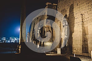 Sunset View to the Illuminated Stone Statues of the large Ancient Egyptian temple in Luxor