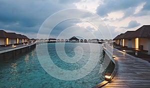 Sunset View to the Luxury Water Villas among Clear Blue Water with White Sand in the Heart of Indian Ocean