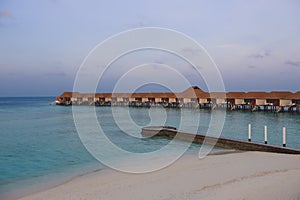 Sunset View to the Luxury Water Villas among Clear Blue Water with White Sand in the Heart of Indian Ocean