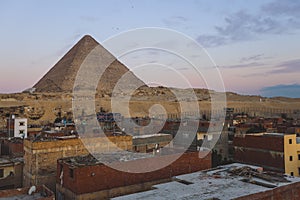 Sunset View to the One of the Wonders of the Ancient World - Great Pyramids of Giza with Colorful Sky and Evening Lights of the Su