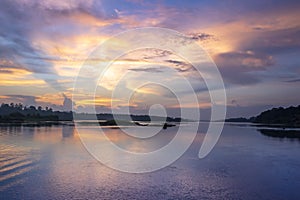 Sunset view of the Victoria Nile river, with trees growing and the reflections on the water, Jinja, Uganda