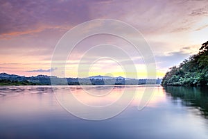 Sunset view of the Victoria Nile river, with trees growing and the reflections on the water, Jinja, Uganda