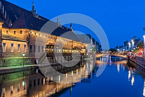 Sunset view of waterfront of a channel passing ancienne douanne building in Strasbourg, France