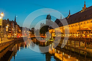 Sunset view of waterfront of a channel passing ancienne douanne building in Strasbourg, France
