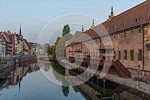 Sunset view of waterfront of a channel passing ancienne douanne building in Strasbourg, France photo