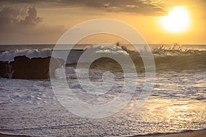 Sunset wave crushing rocky coastline