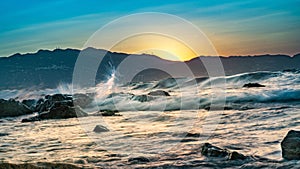 sunset, waves breaking on rocks