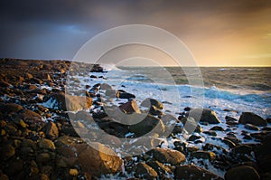 Sunset with waves on rocks