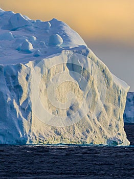 Sunset in the Weddell Sea with dramatic light on ice bergs