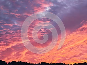 sunset in a winter day. Sunshine over the hill and houses. Silhouettes