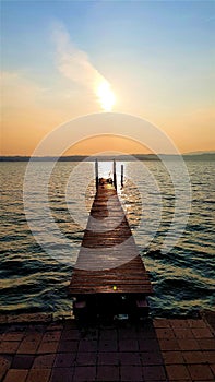 Sunset at a wooden jetty at lake Garda in Italy