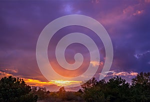 Sunset in the woods with bulky colorful clouds