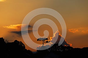 Sunset with yellowish sky full of orange clouds, with tropical rainforest in the background photo