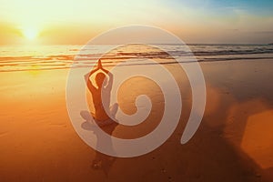 Sunset yoga woman meditation on Ocean coast. Relax.
