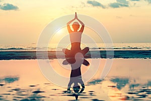 Sunset yoga woman on sea coast. Relax.