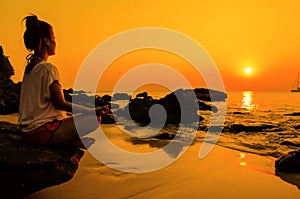 sunset yoga woman with spirituality on sea coast photo