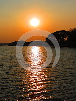 Sunset on the Zambezi river with sky and yellow sun photo