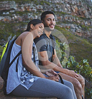 Sunsets are better with you by my side. Shot of a young couple enjoying the sunset view while out on a hike on a