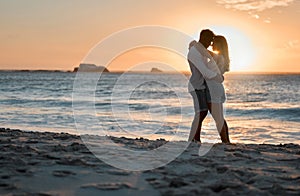 Sunsets and soulmates. a young couple spending time together at the beach.