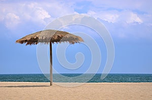 Sunshade on beach with blue sky and white cloud